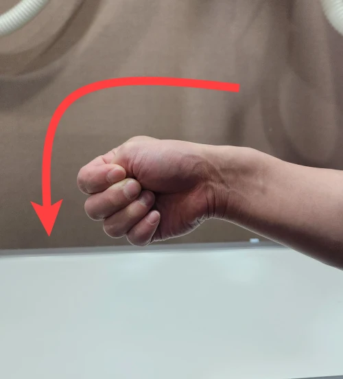 손목 통증 자가진단위해 핀켈스타인 테스트를 하고있다. 엄지손가락을 나머지 손가락으로 감싸쥐고 아래로 꺽고있는 사진이다.